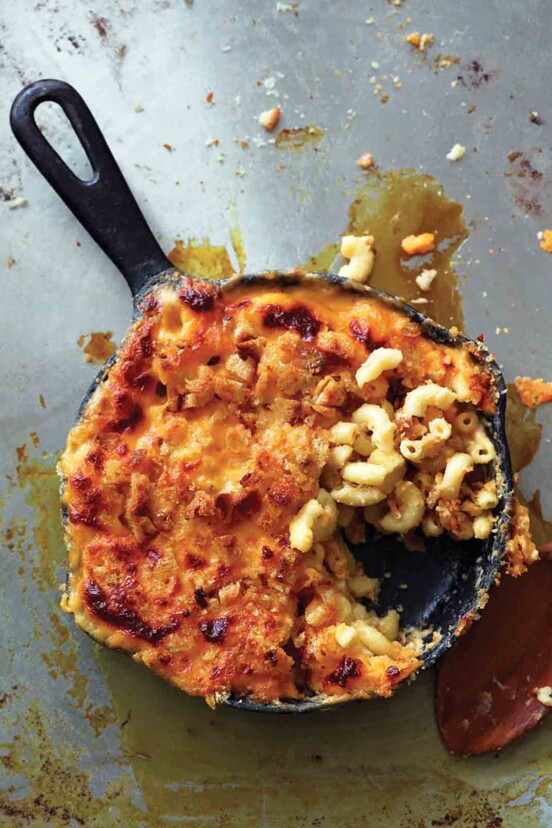 A cast iron skillet filled with baked macaroni and cheese.