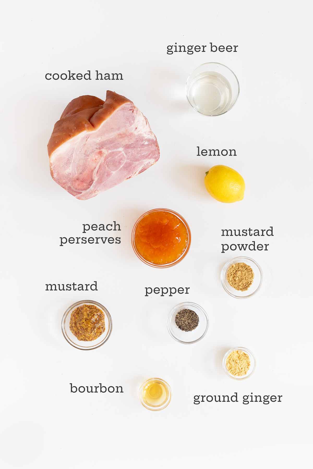 Ingredients for Instant Pot ham in separate bowls -- cooked ham, ginger beer, lemon, spices, and peach preserves.