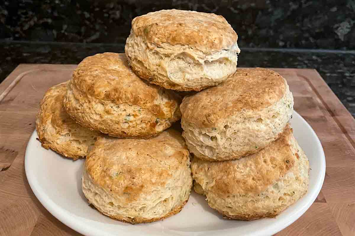 Seven Parmesan cheese biscuits stacked on a plate.