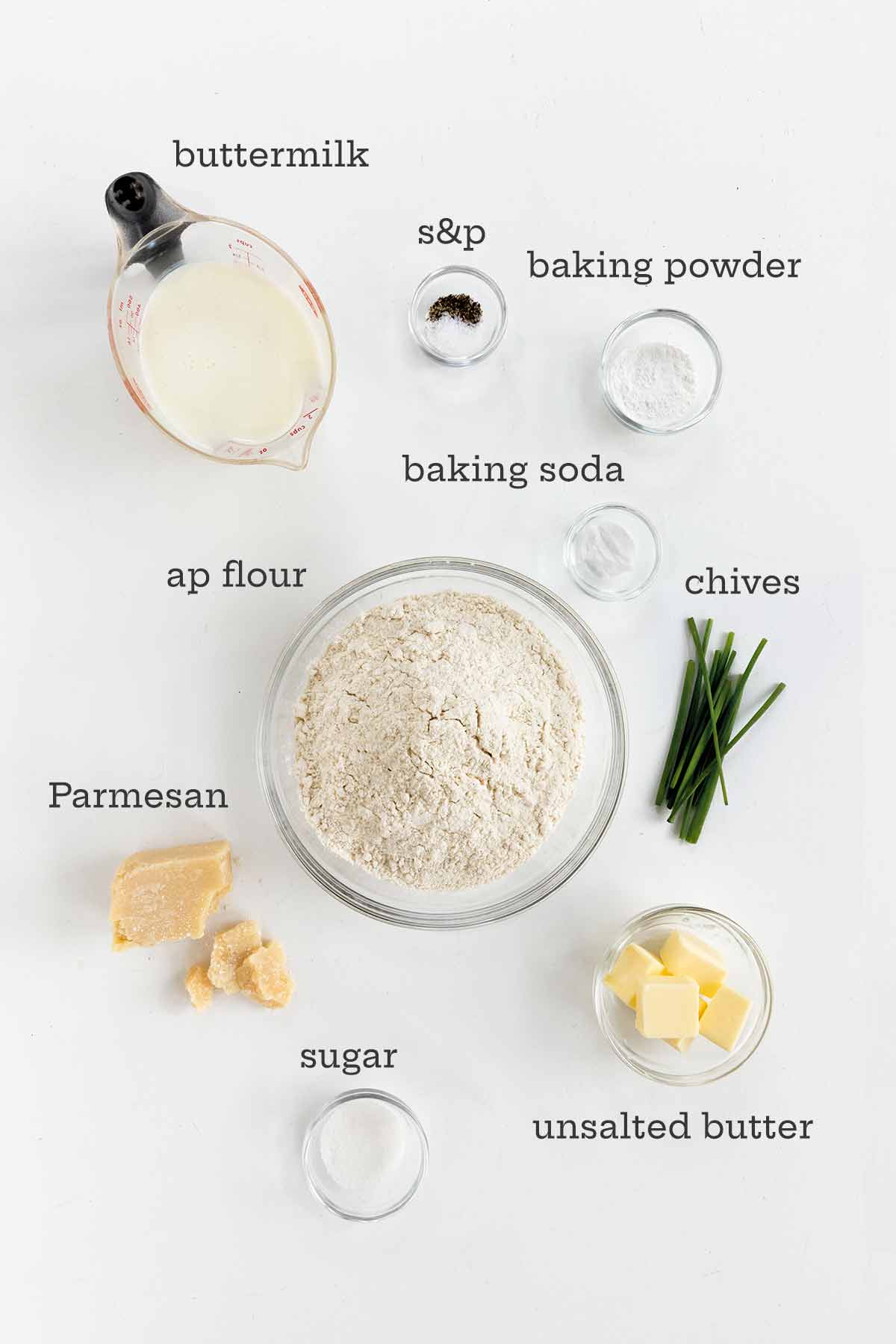 Ingredients for Parmesan cheese biscuits -- flour, buttermilk, baking powder, chives, butter, sugar, and cheese.