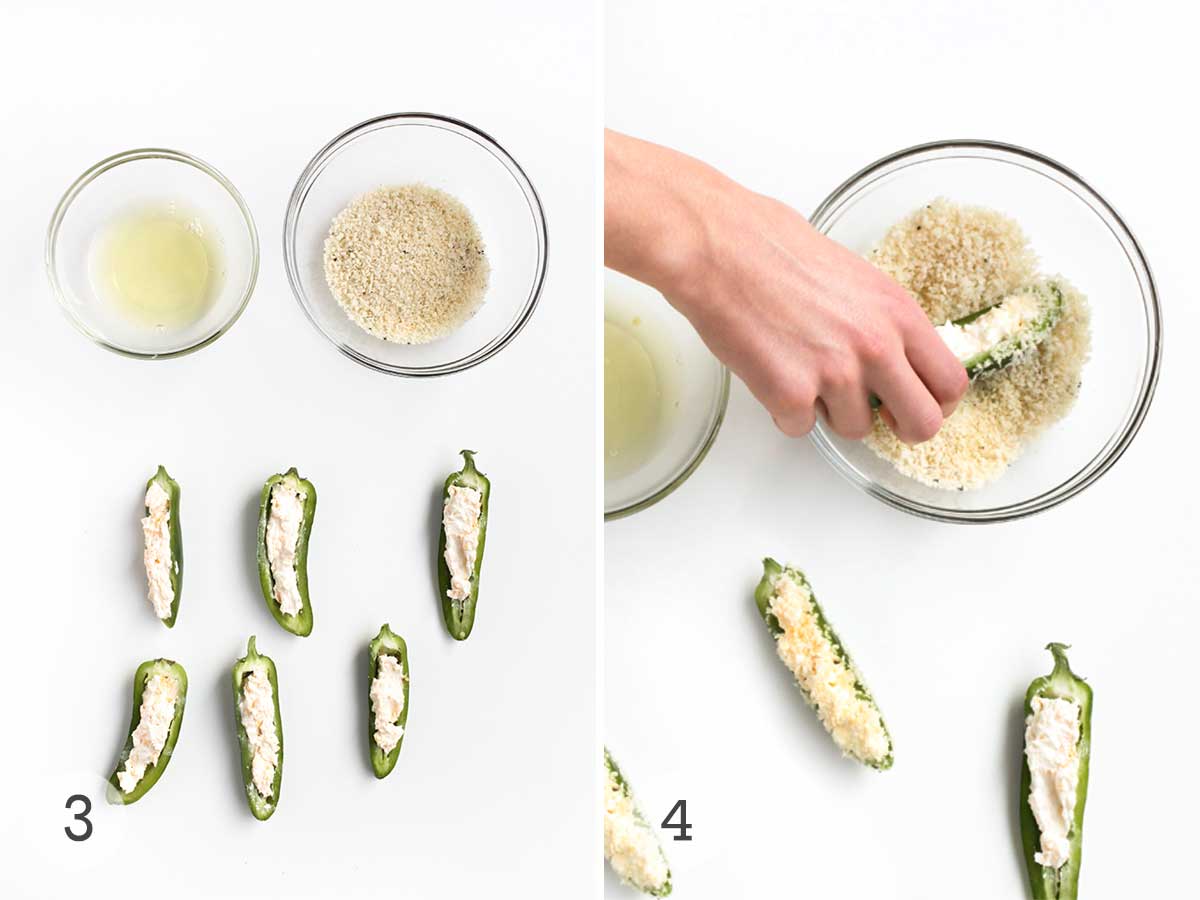 Six jalapeno poppers filled with cheese mixture and a bowl of egg whites and bread crumbs for dredging and a hand dipping one in bread crumbs.