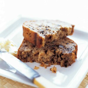A broken slice of banana bread stacked on a white plate