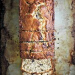 A partially sliced loaf of chocolate bourbon banana bread.