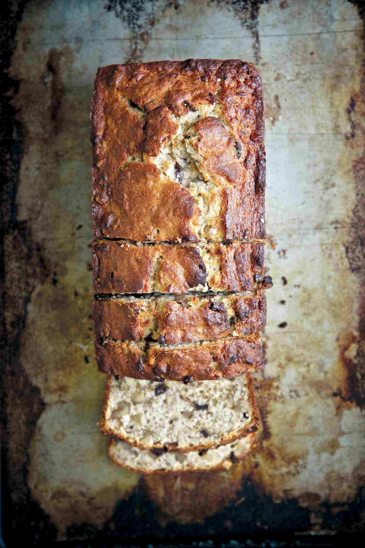 A partially sliced loaf of chocolate bourbon banana bread.