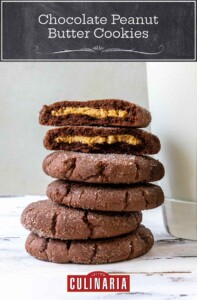 Chocolate peanut butter cookies in a stack, the top one broken in half, on a worn white background.