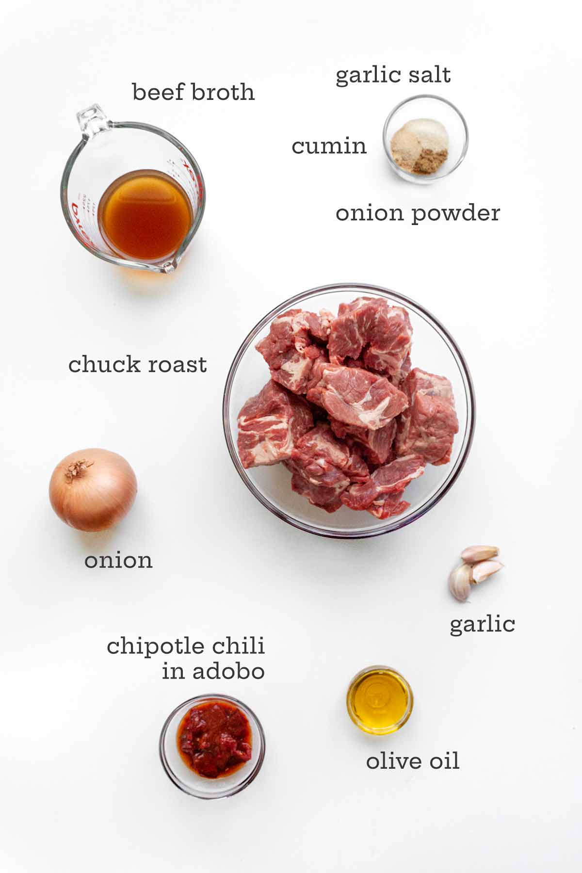 The ingredients for Instant Pot chuck roast--beef, broth, spices, onion, chipotle, oil, and garlic.