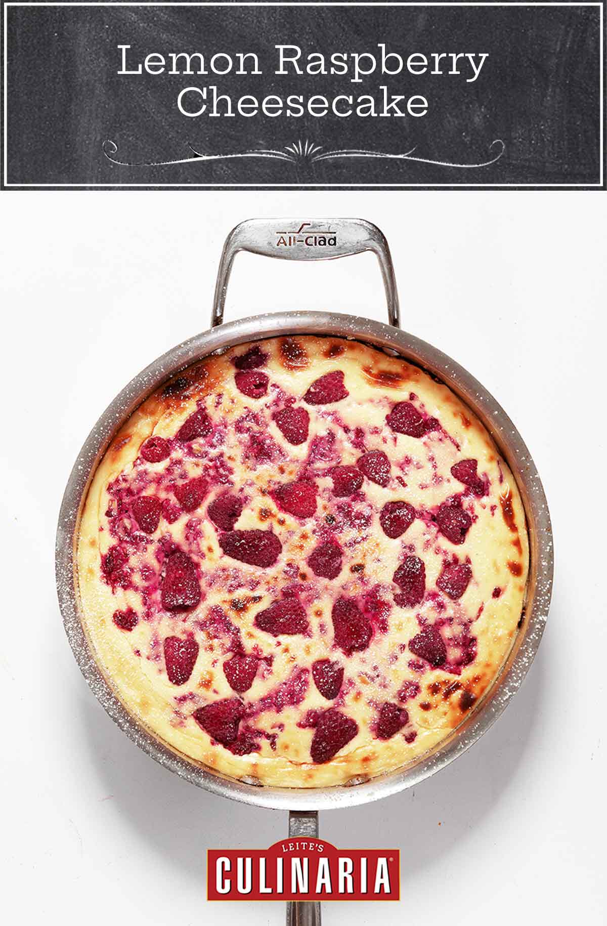 A baked lemon raspberry cheesecake topped with raspberries in a metal skillet.