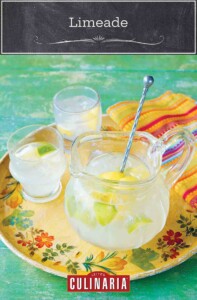 A pitcher and two glasses of limeade on a colorful platter with a linen napkin on the side.