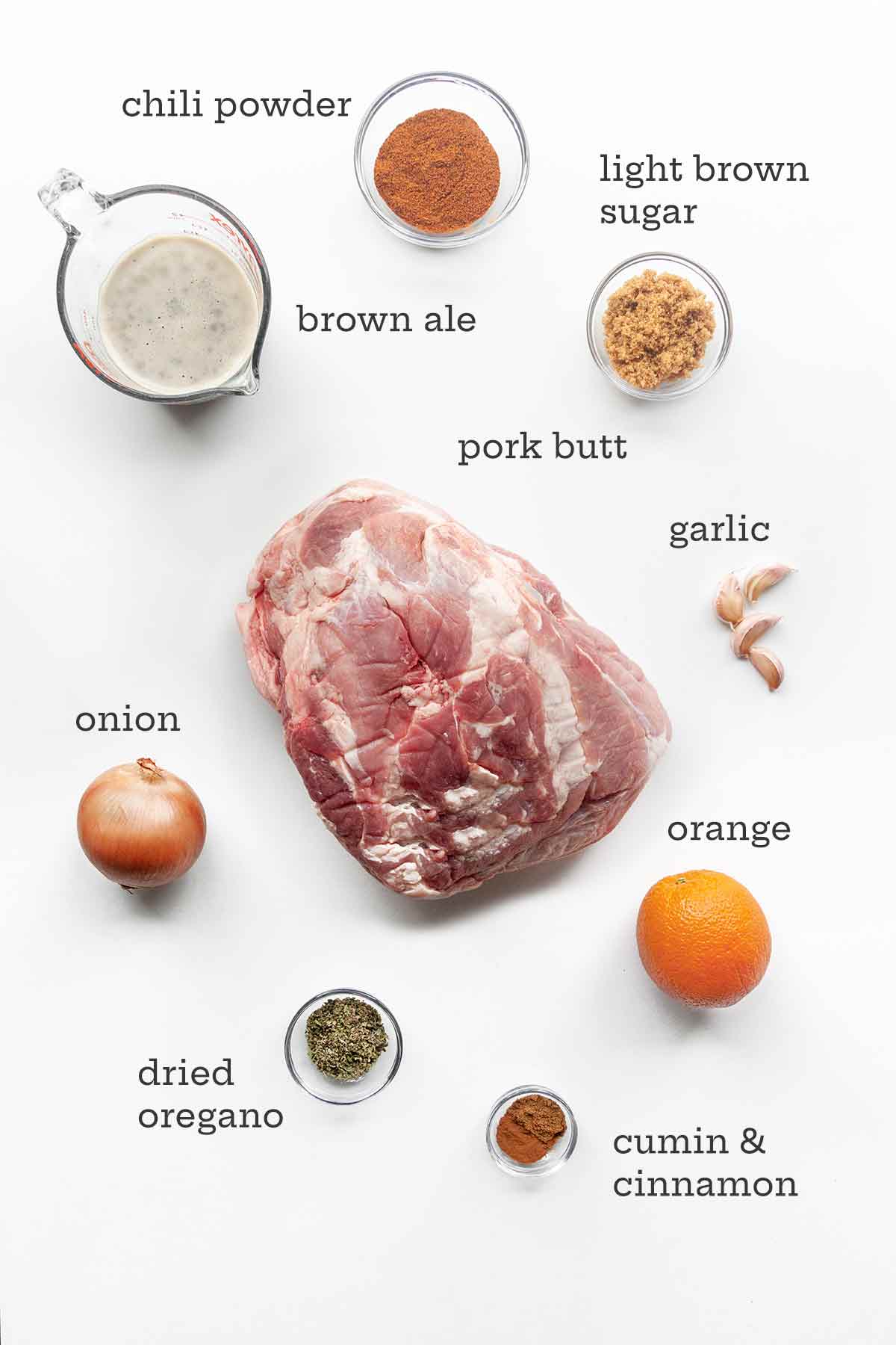 The ingredients for pork tacos--pork butt, garlic, sugar, spices, onion, orange, and ale.