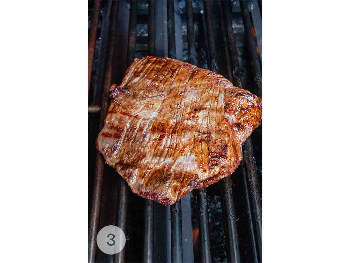 A piece of grilled skirt steak on a grill.