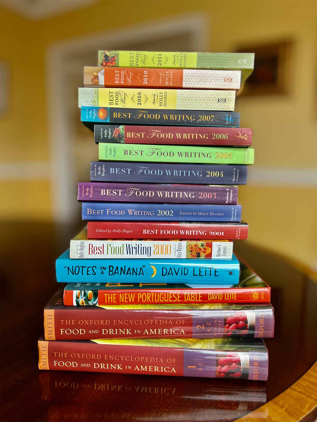A pile of food books, cookbooks, and encyclopedias that feature David Leite's work.