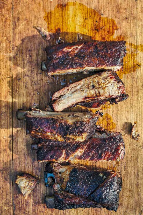 Five Memphis-style ribs cut into individual pieces on a wooden cutting board.