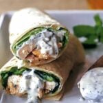 A tandoori chicken wrap with lettuce, chicken, in a flour tortilla.