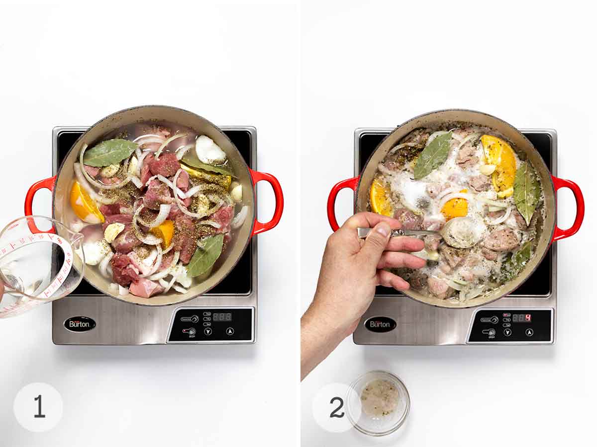 Water being poured into a Dutch oven filled with pork, onion slices, orange wedges, and bay leaves and a person stirring the mixture.