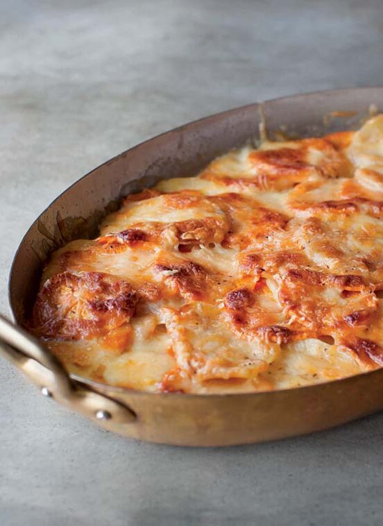 An oval casserole filled with sweet potato gratin.