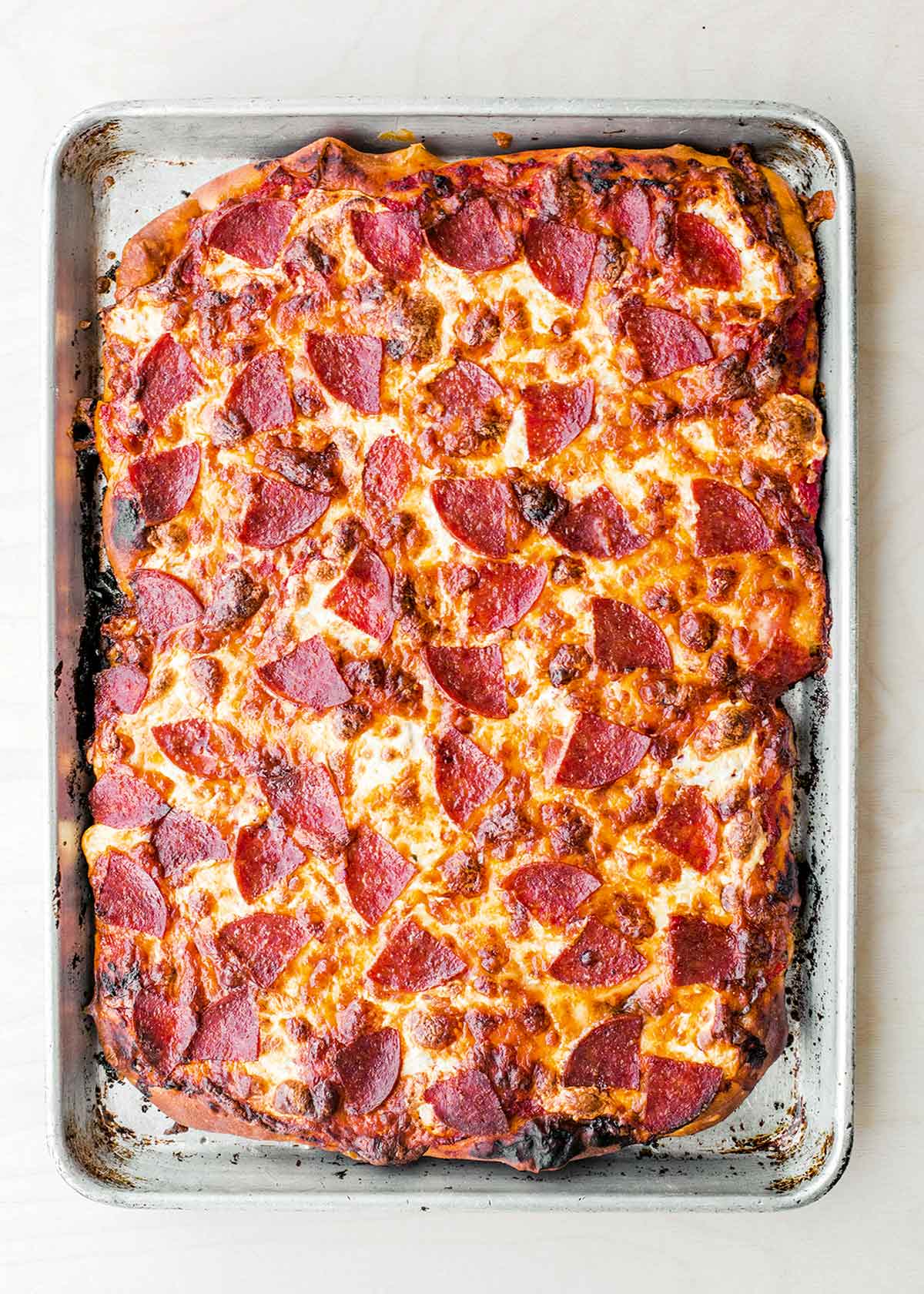 A pepperoni pan pizza in a rectangular baking sheet.