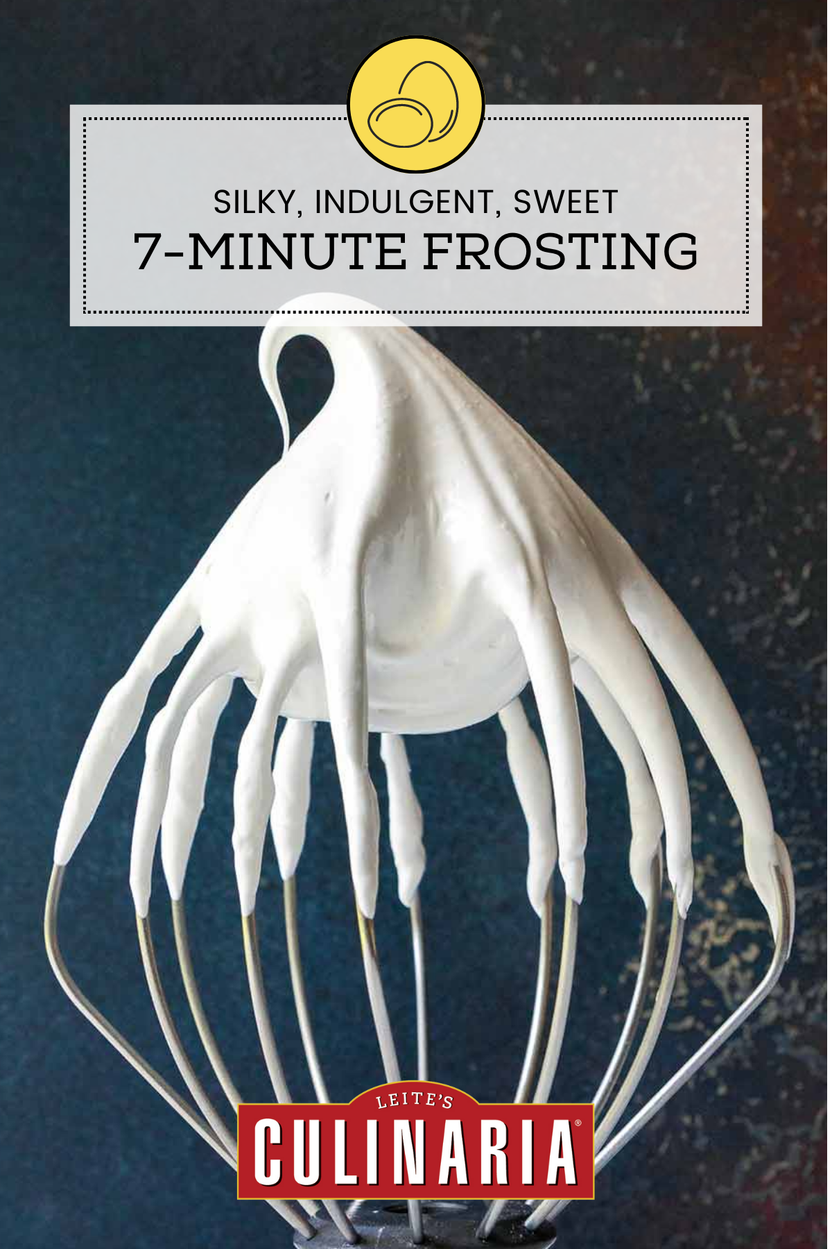 A large stand-mixer beater covered with white, fluffy seven minute frosting.
