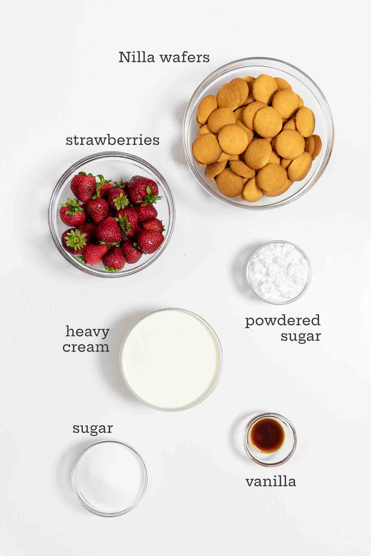 Ingredients for strawberry icebox cake--Nilla wafers, strawberries, powdered sugar, cream, granulated sugar, and vanilla.
