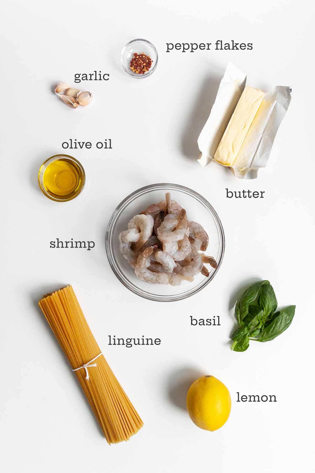 Ingredients for garlic butter shrimp pasta--pasta, shrimp, basil, lemon, butter, pepper flakes, garlic, and olive oil.