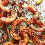 A pile of grilled half-moon slices of butternut squash.