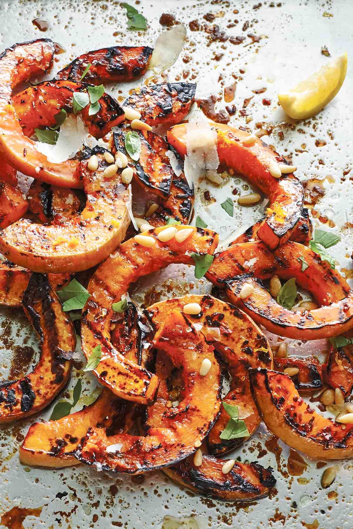 A pile of grilled half-moon slices of butternut squash.