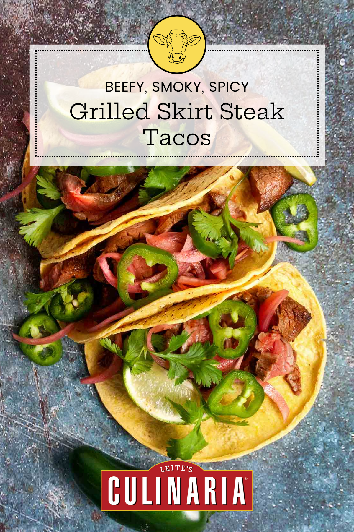 Sliced skirt steak on a wooden board with tortillas, lime wedges, cilantro, jalapeno, and pickled red onion.