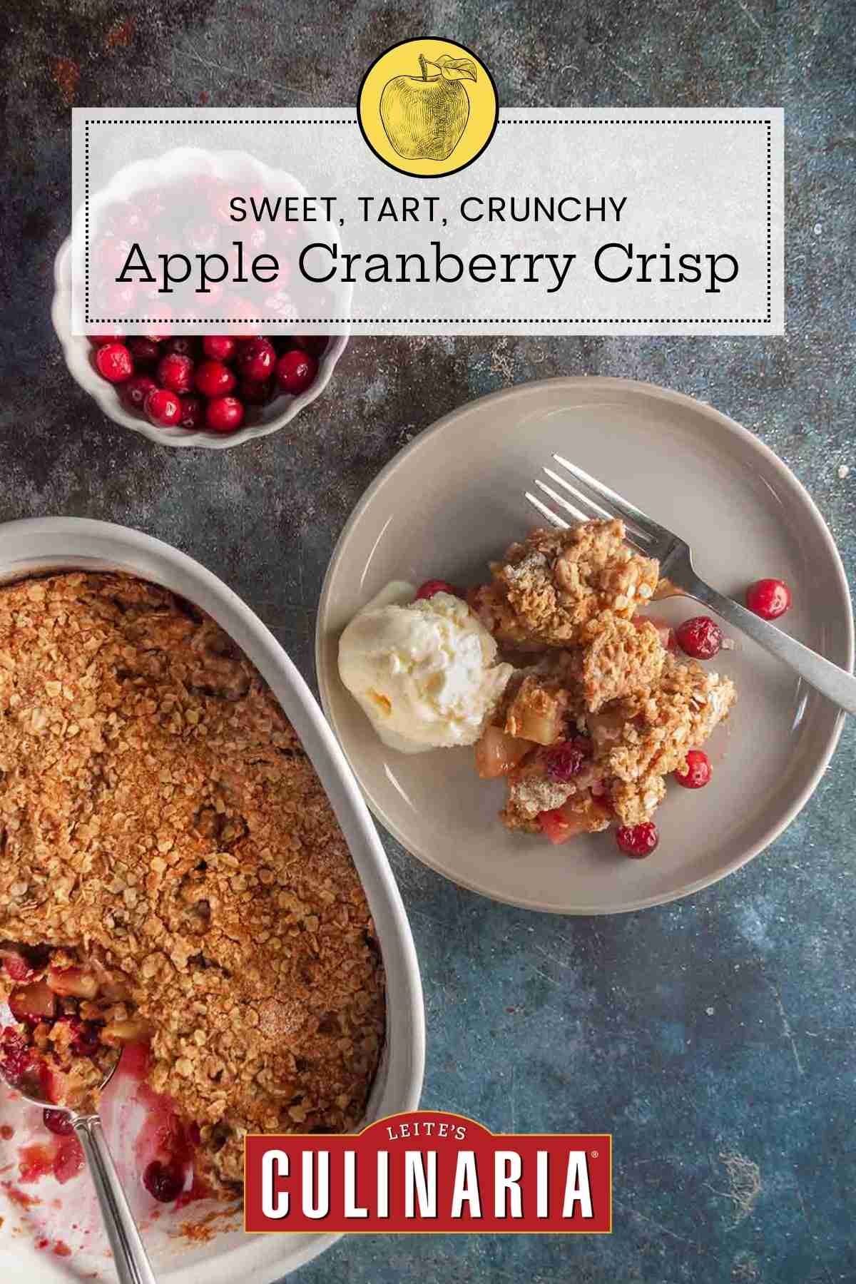 A plate with a serving of apple cranberry crisp, a scoop of vanilla ice cram, and a fork on the side.
