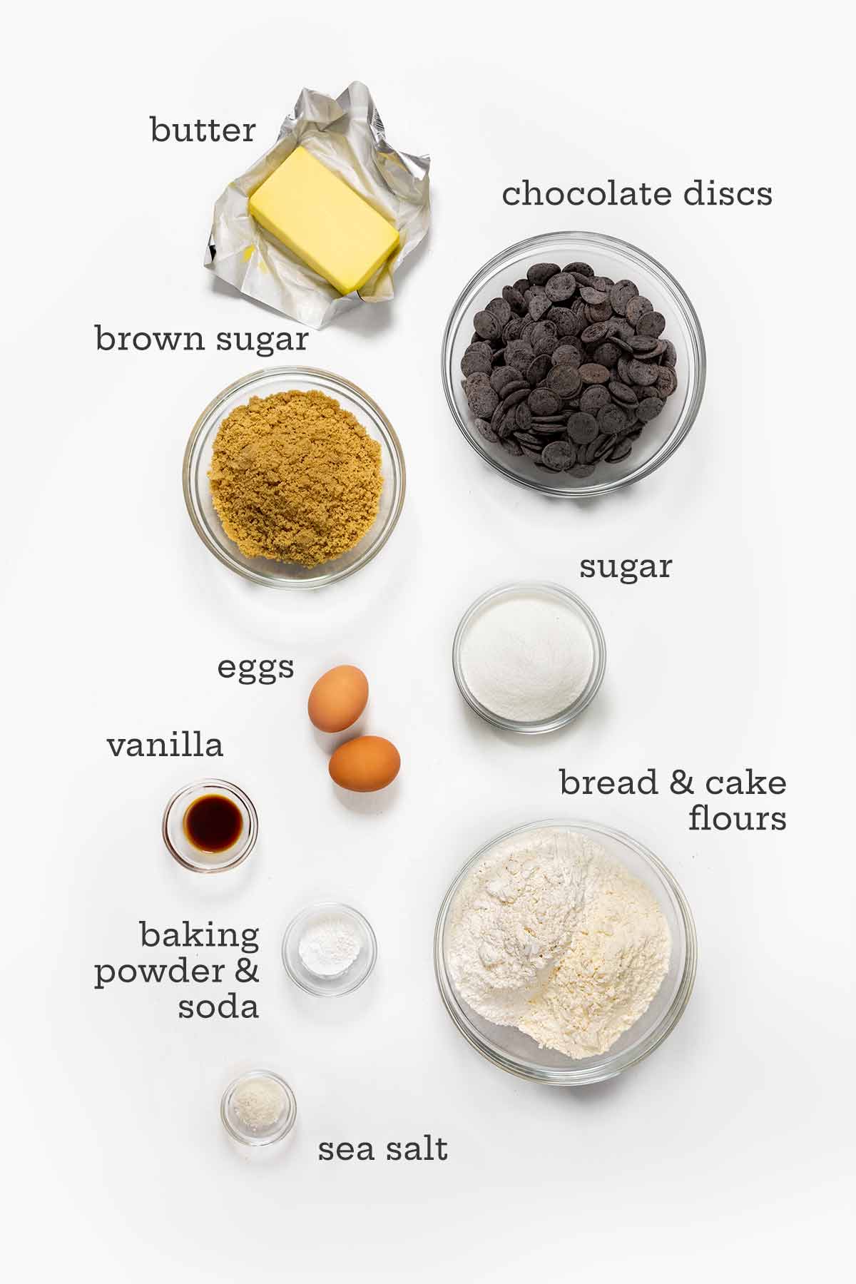 Ingredients for New York Times' chocolate chip cookies--sugars, flours, butter, chocolate discs, eggs, vanilla, salt, and baking soda and powder.