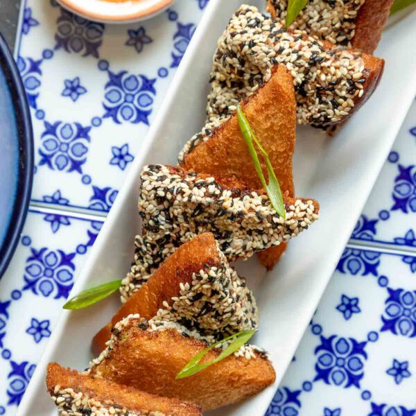 A rectangular platter of shrimp toast on top of blue and white tiles.