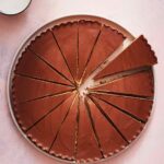 A giant peanut butter cup on a plate, cut into 15 wedges.