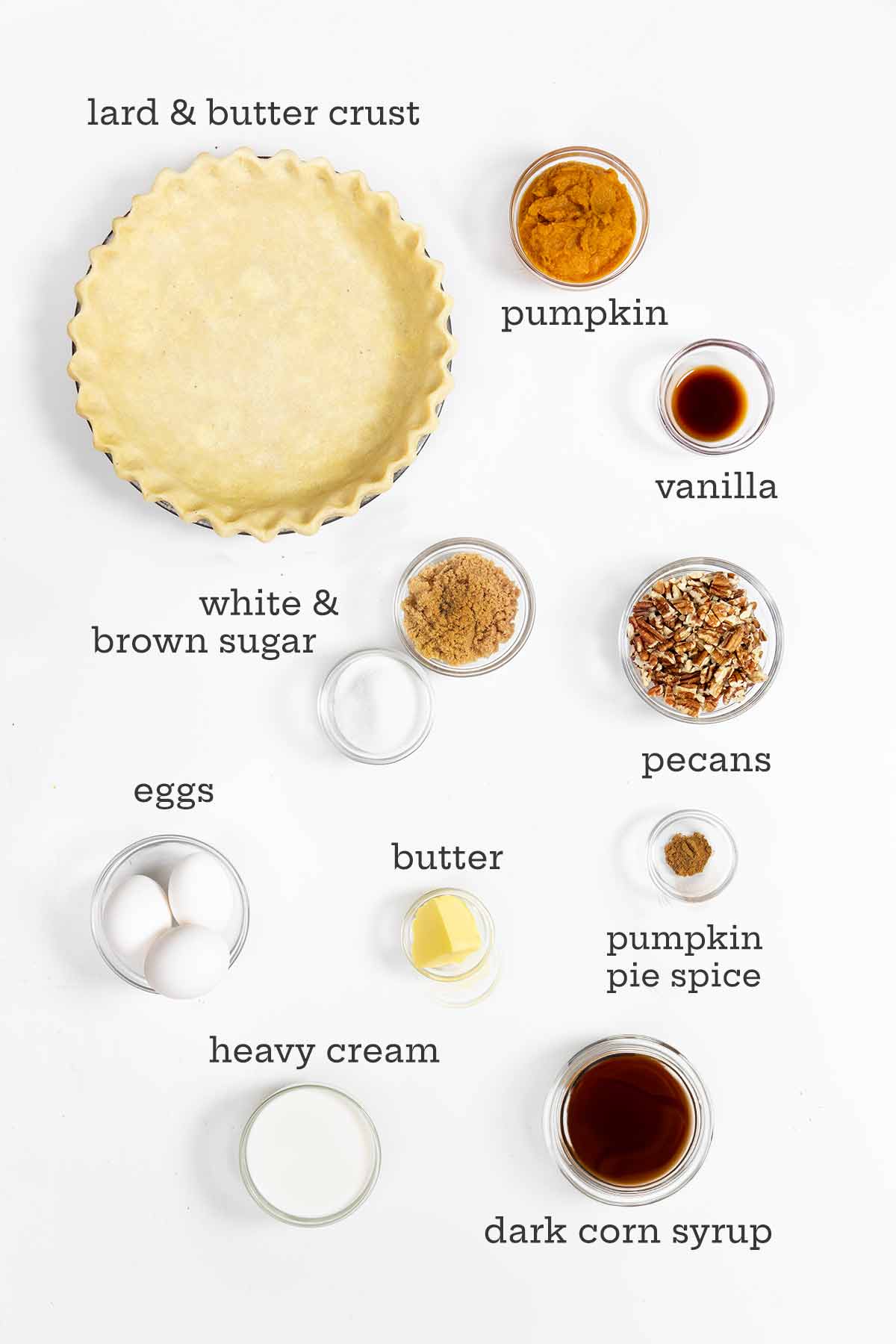 Ingredients for pumpkin pecan pie--crust, pumpkin, vanilla, pecans, sugar, eggs, butter, cream, corn syrup, and pumpkin pie spice.