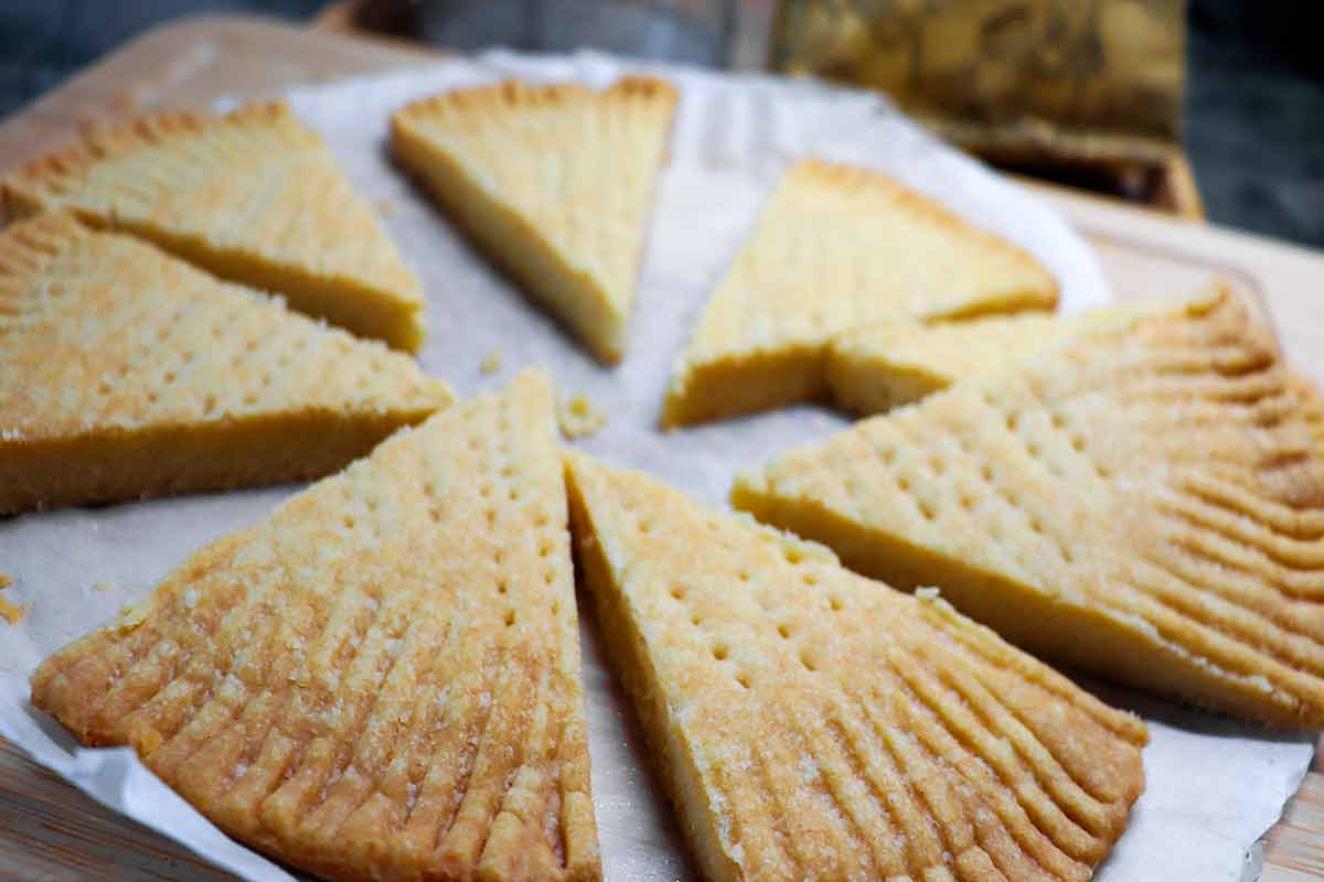 Wedges of Scottish shortbread on a round sheet of parchment paper.