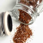 BBQ dry rub seasoning spilling out of a jar.