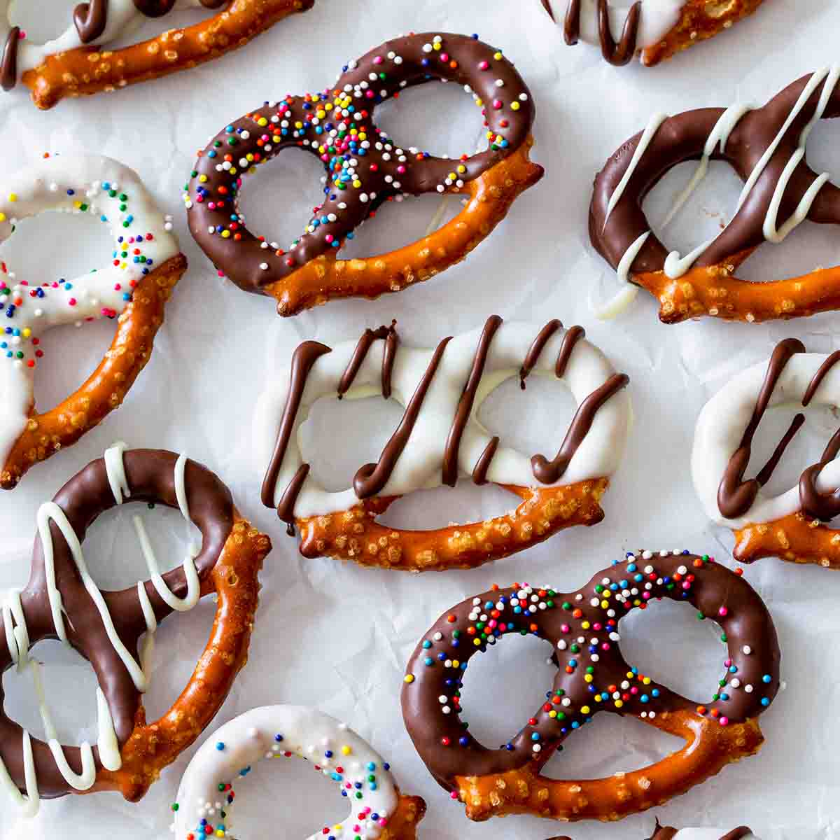 An assortment of chocolate covered pretzels with white and dark chocolate coating and sprinkles.
