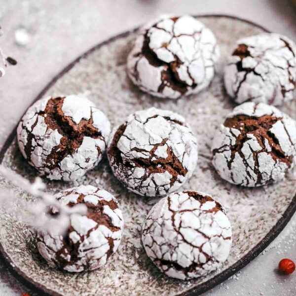 A plate with seven chocolate-ginger crinkle cookies.