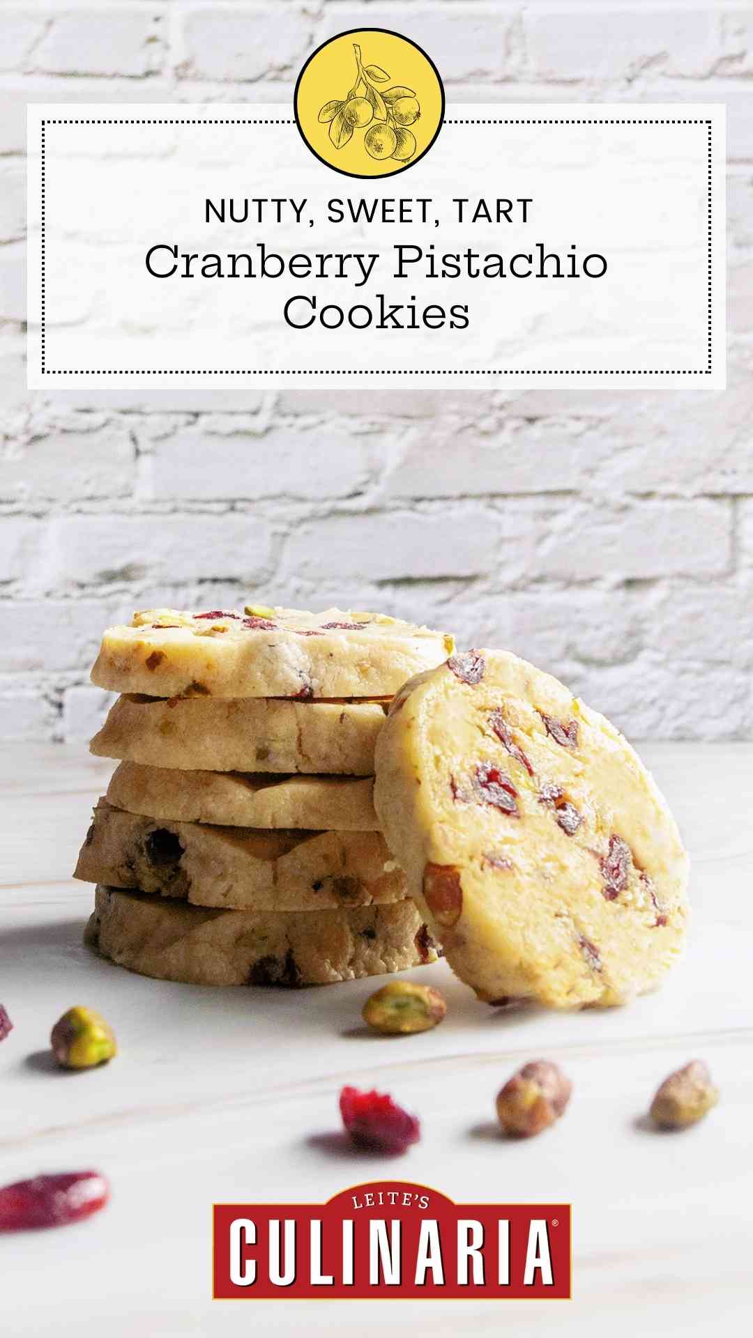 Five stacked cranberry pistachio cookies with another cookie leaning against the stack.