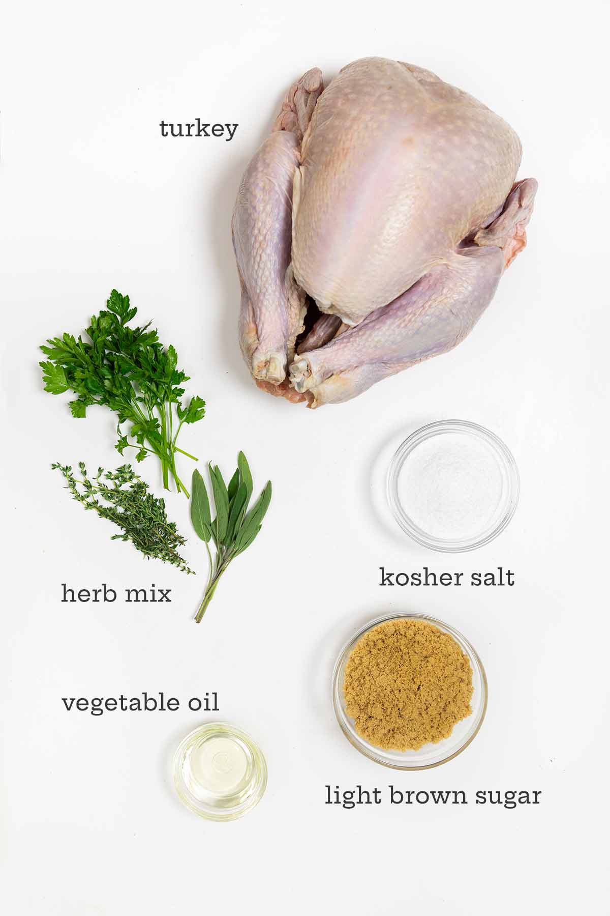 Ingredients for dry brine turkey--turkey, herbs, kosher salt, oil, and brown sugar.