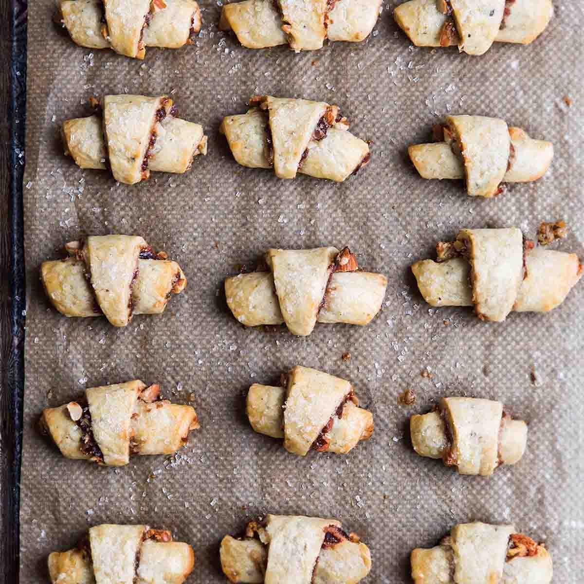 A baking sheet with four rows of baked fig rugelach.