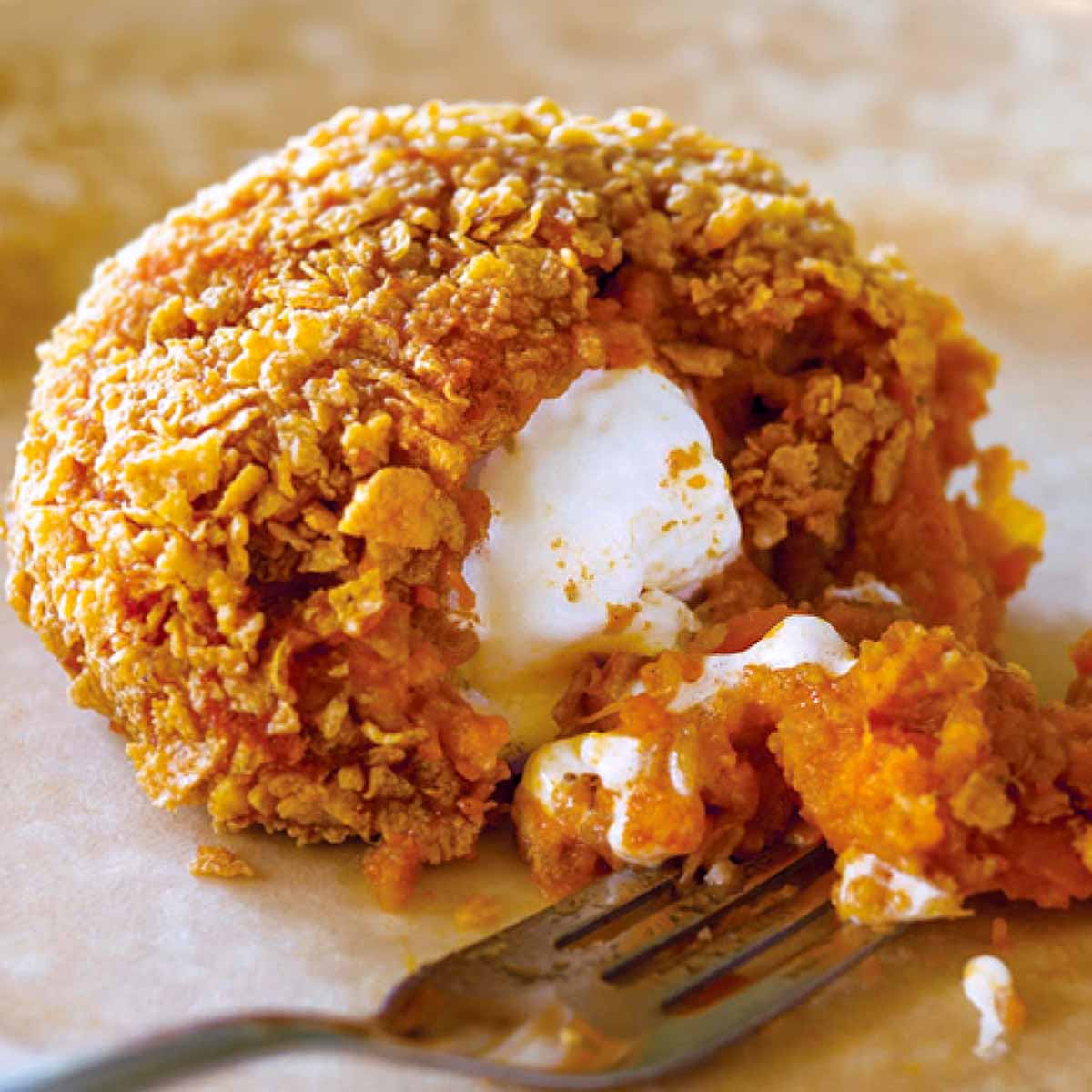 An inside-out sweet potato coated in corn flakes, with a marshmallow center.