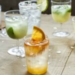 Two glasses of lime soda and one glass of angostura orange.