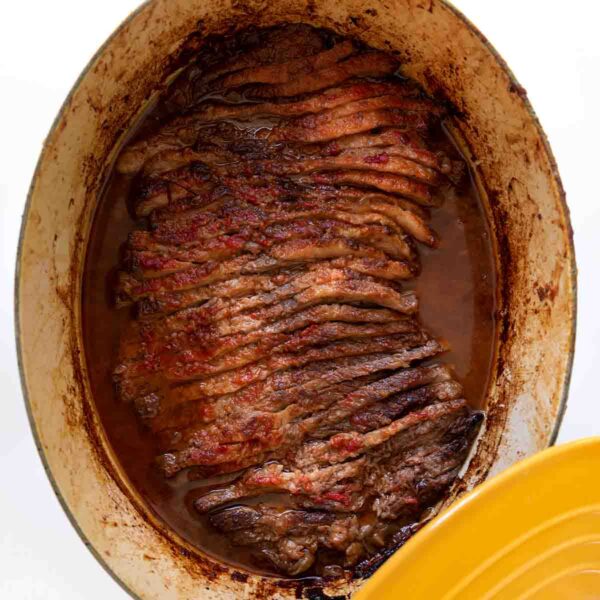 A yellow Le Creuset pot with Nach Waxman's sliced beef brisket inside.