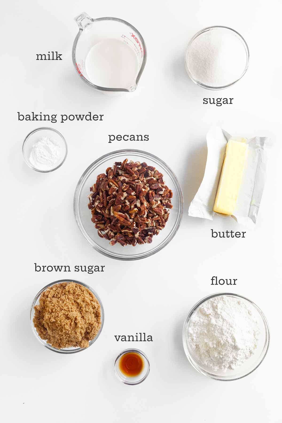 Ingredients for pecan pie cobbler--pecans, milk, sugar, flour, butter, vanilla, and baking powder.