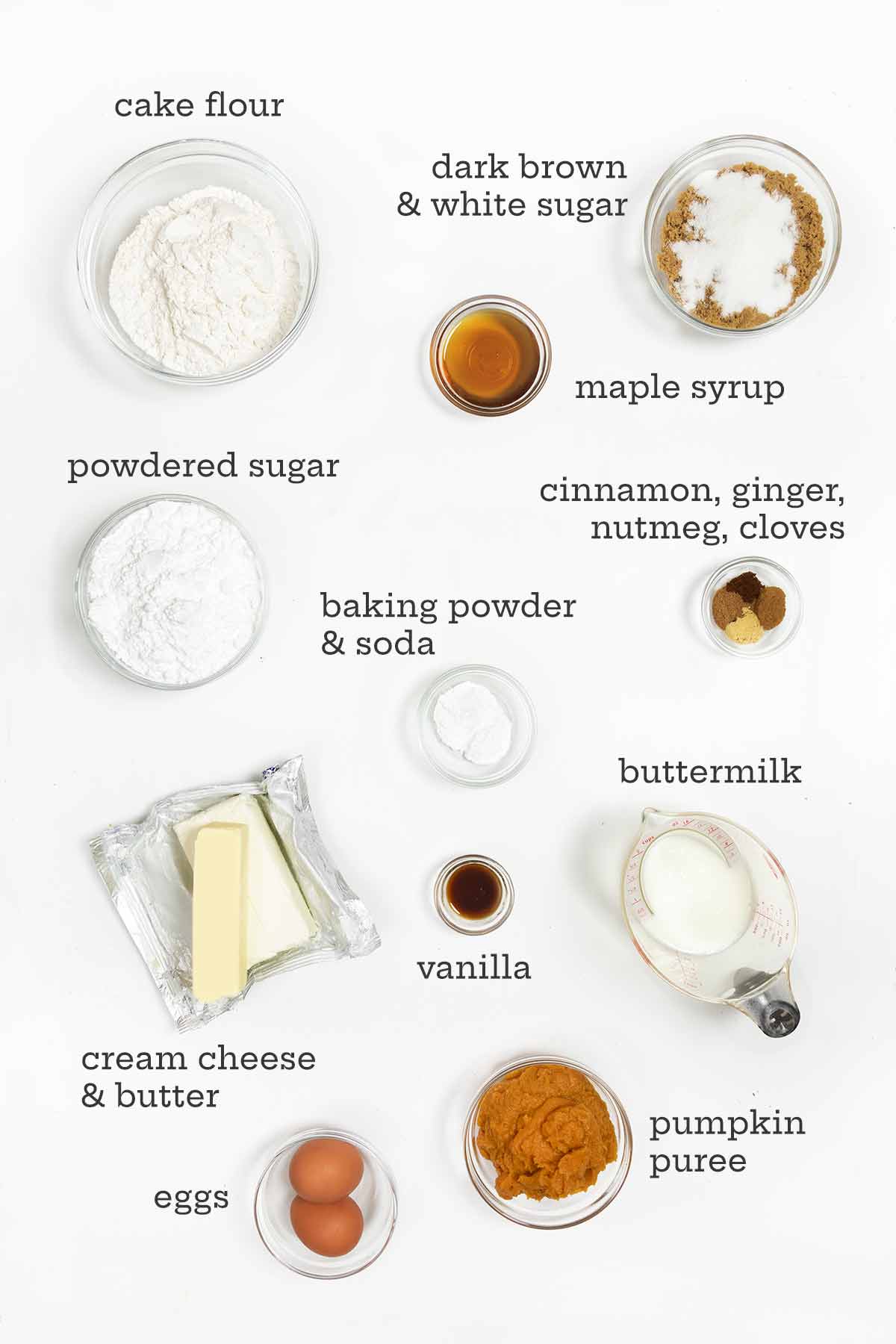 Ingredients for pumpkin cake with maple cream cheese frosting--flour, sugars, maple syrup, spices, butter, cream cheese, eggs, buttermilk, and pumpkin.