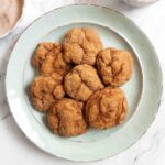 Seven pumpkin spice cookies on a green plate.