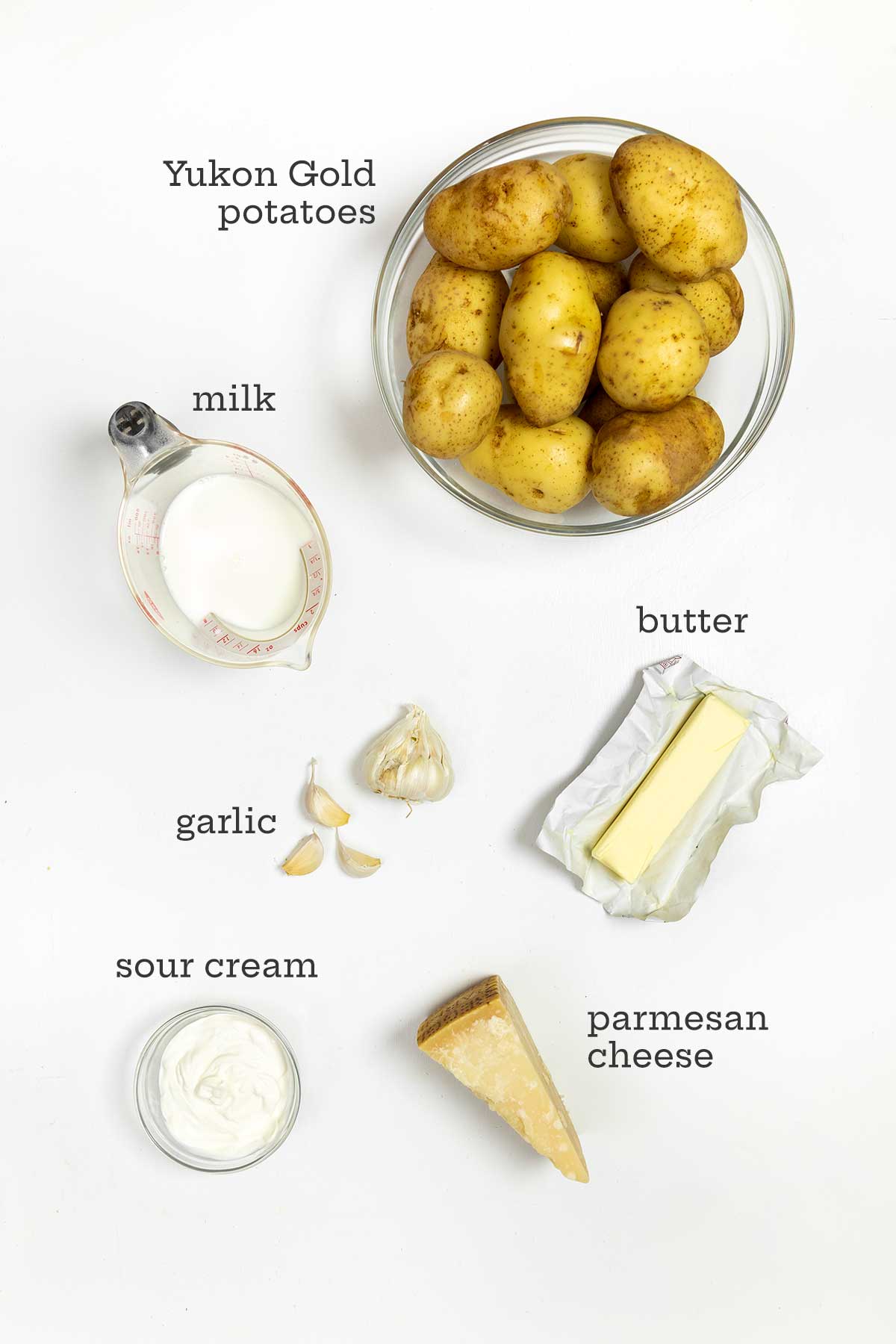 Ingredients for roasted garlic mashed potatoes--potatoes, milk, butter, garlic, parmesan, and sour cream.