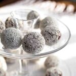 A two-tiered platter with rum balls on each tier.