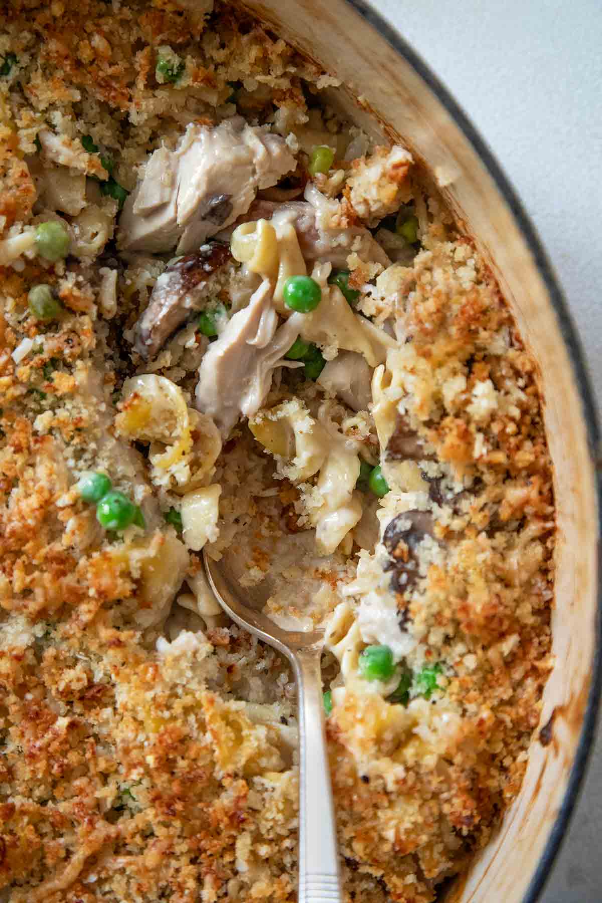 A serving spoon resting inside a Dutch oven filled with turkey tetrazzini.