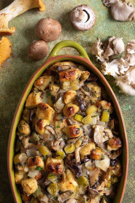 An oval casserole dish filled with wild mushroom stuffing.