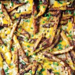 A scattering of chili cheese fries topped with cheddar and snipped fresh chives.