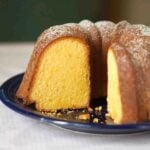 A partially cut Portuguese orange olive oil cake.